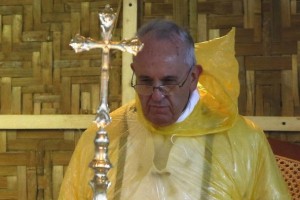 Pope Francis, in a rain poncho, attends during a Mass near Tacloban airport January 17, 2015. Storms greeted Francis when he arrived in the central Philippines city of Tacloban on Saturday to pray for the dead and comfort survivors of Typhoon Haiyan, the country's worst natural disaster that killed 6,300 people barely a year ago.   REUTERS/ Stefano Rellandini  ( PHILIPPINES - Tags: RELIGION ENVIRONMENT TPX IMAGES OF THE DAY) - RTR4LRKH