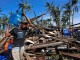 A typhoon victim carries a gas tank for cooking past a house destroyed by Typhoon Hagupit in Borongan city, Samar Photo: ERIK DE CASTRO/REUTERS